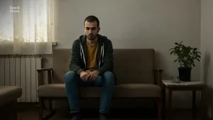 مردی که تنها و ناراحت روی مبل نشسته است.