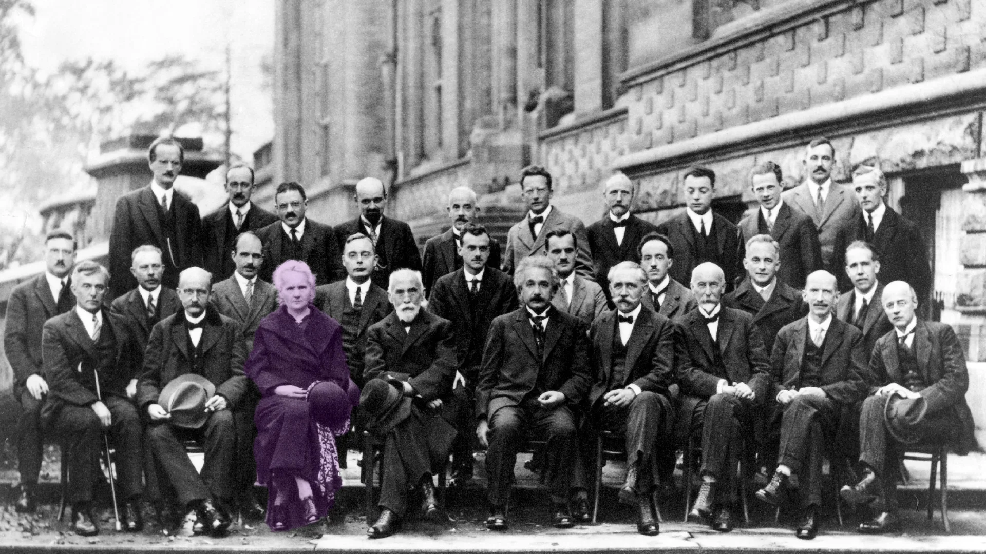 تصویر تاریخی کنفرانس سولوی ۱۹۲۷ است که بیشتر شرکت‌کنندگان مرد هستند. تنها زن حاضر، ماری کوری در ردیف جلو نشسته است.