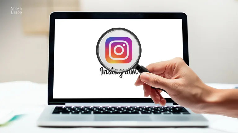 تصویر یک لپ‌تاپ را نشان می‌دهد که لوگوی اینستاگرام روی صفحه سفید آن دیده می‌شود. دستی در حال نگه داشتن ذره‌بین است که لوگوی اینستاگرام را بزرگ‌نمایی کرده و بر آن تمرکز کرده است.