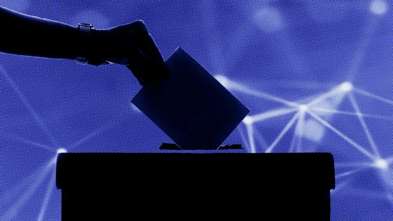 نمایی از یک دست در حال انداختن رای به صندوقی در تاریکی