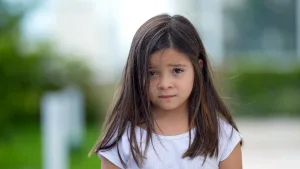 دختربچه خردسالی که با نگرانی و اضطراب به روبه‌رو خیره شده است.