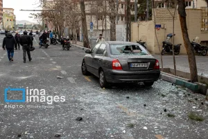 خودرویی با شیشه‌های خردشده در خیابان پس از انفجار، در حالی که تکه‌های شیشه روی آسفالت ریخته است