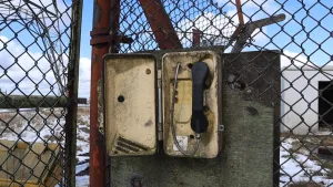 تصویری از یک باجه تلفن قدیمی در کنار یک دکل مخابراتی، نمادی از ارتباطات رادیویی دوران جنگ سرد.