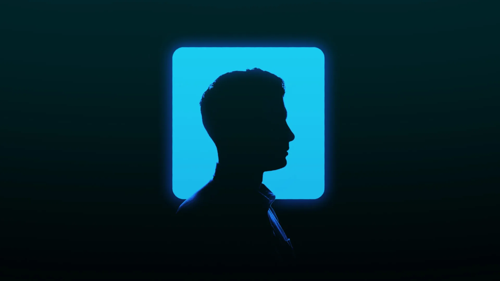 سایه مردی که در پیش‌زمینه لوگوی مربعی آبی‌رنگ لینکدین با نور خیره‌کننده قرار گرفته.