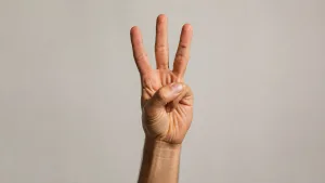 دستی که سه انگشت را بالا گرفته است، نمادی از «قانون سه»